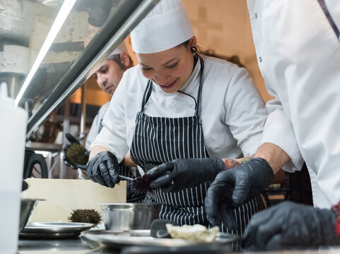 Chefs Preparing Seafood Delicacies in a Busy Kitchen Environment