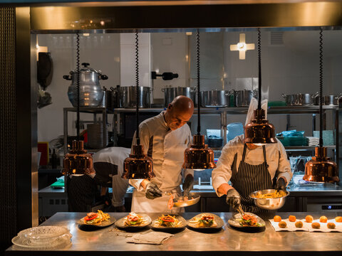 Chefs Preparing Gourmet Dishes in a Modern Restaurant Kitchen