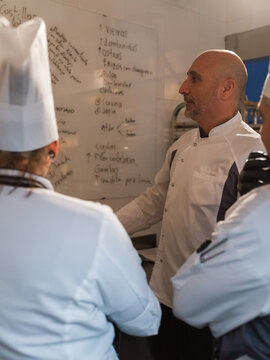 Chefs Discussing Menu Ideas in Restaurant Kitchen