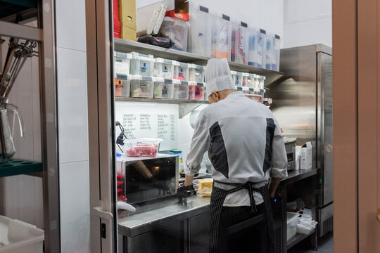 Chef Prepares Ingredients in a Busy Kitchen During Dinner Service