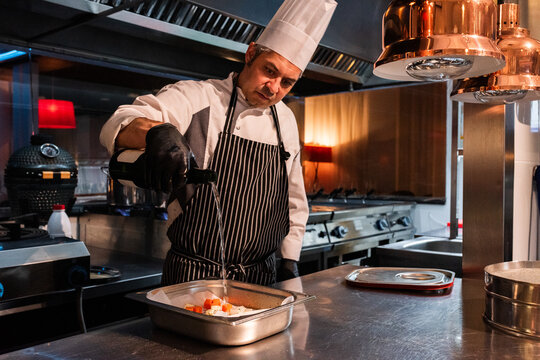 Chef pouring wine in dish