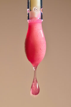 A pink liquid droplet forms and separates