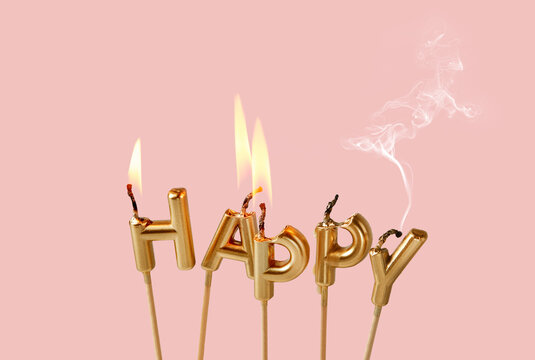 Burnt happy candle letters with smoke on pink