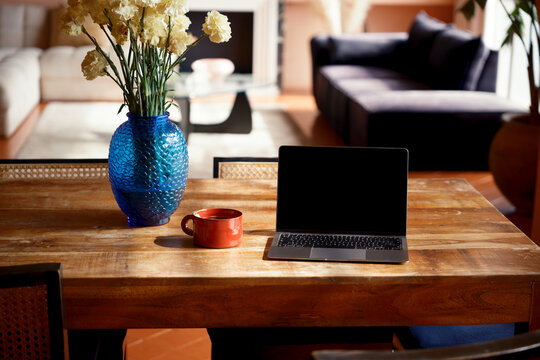 Laptop with blank screen on cozy living room 