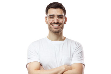 Fototapeta premium Portrait of smiling handsome man in white t-shirt and transparent eyeglasses standing with crossed arms isolated on pink background