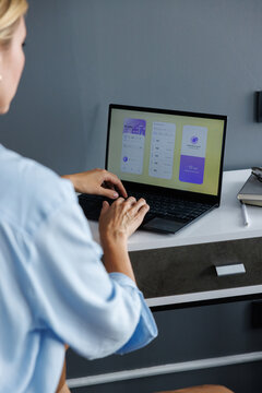 Cropped back view of IT company manager using digital app on laptop