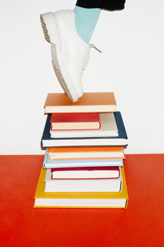 Person standing in top of book pile in work office with flashlight