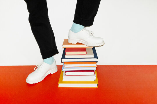 Person standing in top of book pile in work office with flashlight