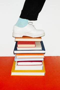 Person standing in top of book pile in work office with flashlight