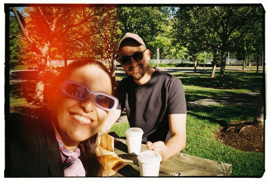 Enjoying Drinks and Snacks in a Sunny Park Setting