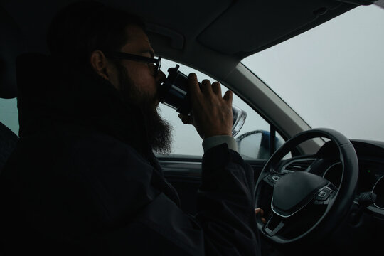 Driver drinking coffee in car