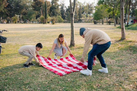 Family Spreading Picnic Blanket Outdoors
