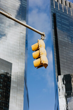 Old yellow traffic light with glass buildings background