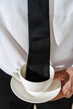 Black tie dipped into coffee cup