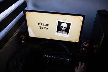 Person Researching Alien Life and Disclosure on Computer in Dark Room, Mystery and Paranormal Research Online Featuring Grey Alien Disclosure Image