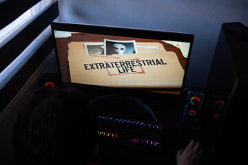 Extraterrestrial Life Top Secret Folder Graphic on Computer Monitor, Anonymous Researcher Viewing Classified Alien Files and Extraterrestrial Photos