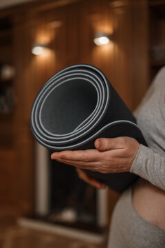 Gymnastic mat in the woman's hands
