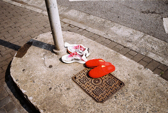 Two pair of shoes on a sidewalk in the streets of shanghai