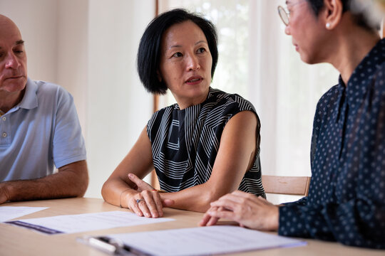 People at a table discussing documents.