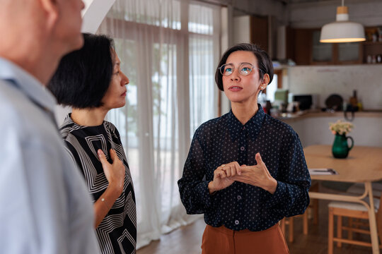 Three people in a modern home, one explaining something.