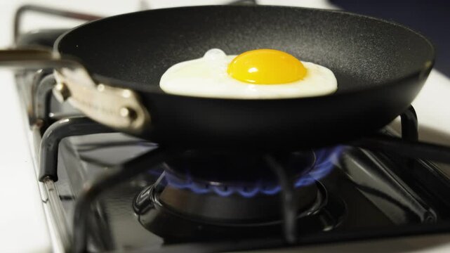 Egg cooks on frying pan gas oven stove