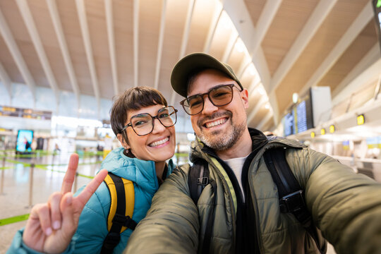 Happy couple taking selfie at airport before travel