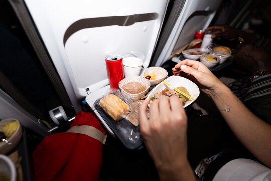 Passenger enjoying inflight meal on airplane traveling
