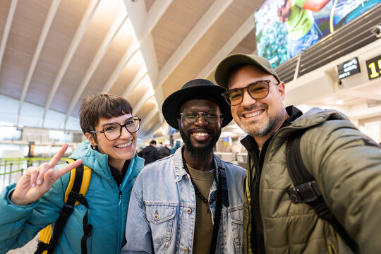 Diverse friends taking happy selfie at airport