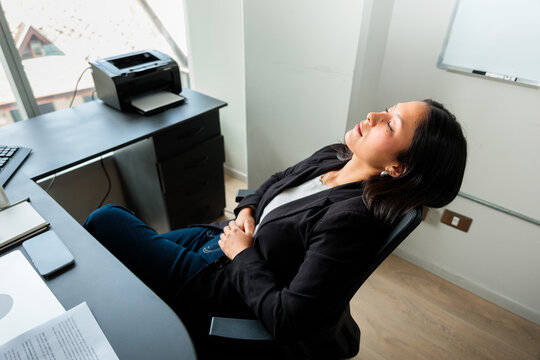 Exhausted Female Employee Taking a Break at Desk
