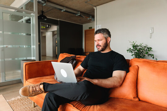 Man Working on Laptop in Modern Coworking Space