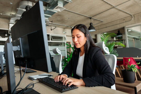Focused Woman Working at Computer in Coworking Space