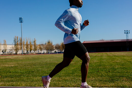 Athlete jogging around the track as a warm-up