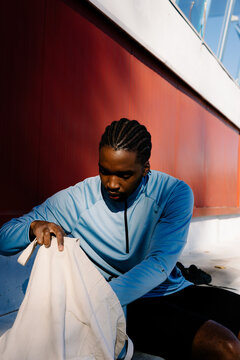 Young athlete putting his things in a blanket bag