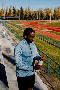 Athlete using a water bottle to rehydrate during a break