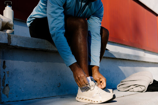 Unknown runner sitting in the seats, securing the laces on his shoes