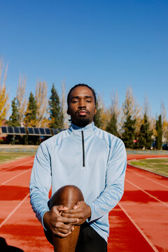 Medium shot of a runner focused on his warm-up and stretching
