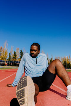 Runner resting on the track taking a moment to steady his breathing