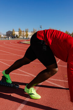 Anonymous athlete positioning his feet on the starting blocks