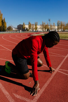 Runner fine-tuning his stance to achieve a stable launch position