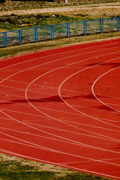 Mid-range view of curved lane markings on a sunlit outdoor track