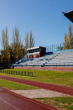 An outdoor athletics complex featuring a sunlit running track