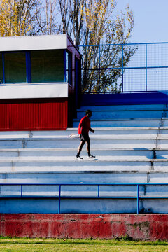 A runner walking on the steps of a sports complex during a warm-up