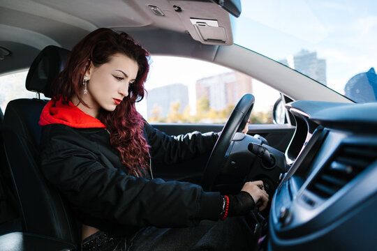 Young woman starting car ignition for urban journey