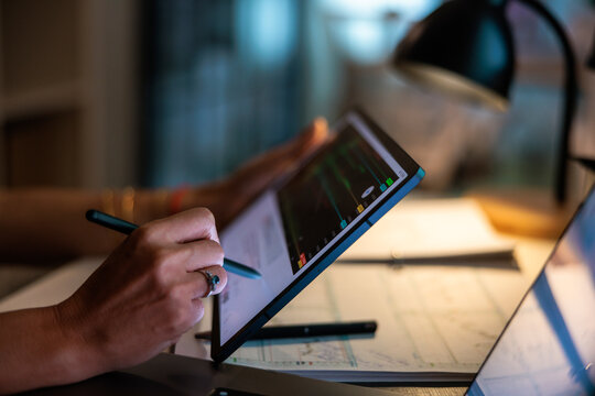 Working late on a tablet with a stylus.