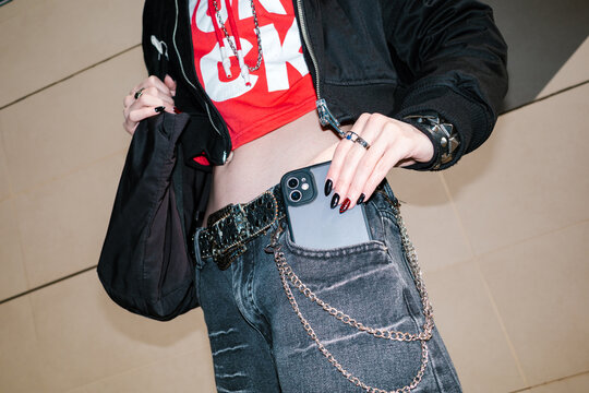 Young man putting a smartphone in his jeans pocket.