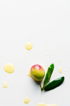Olive with leaves on white background with oil drops