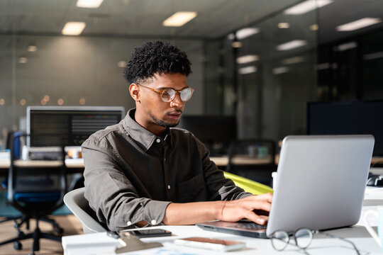 Black man working in office using laptop