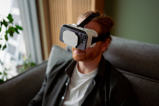Man uses virtual reality headset indoors at home in the afternoon
