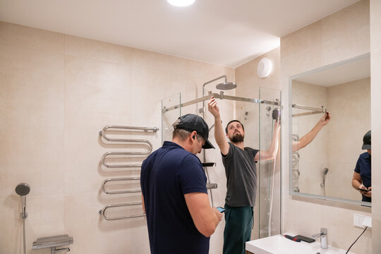 Workers Installing a Shower System in a Modern Bathroom