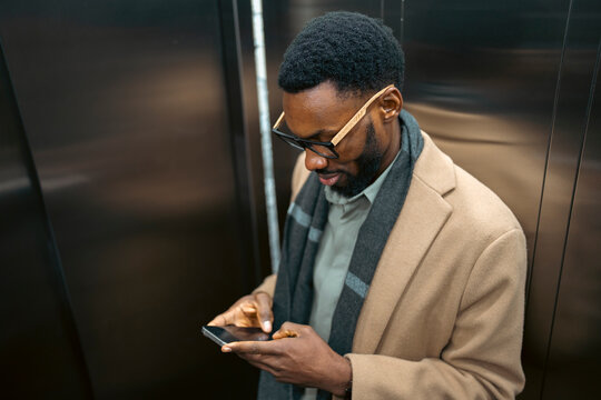 Man checks phone while in elevator